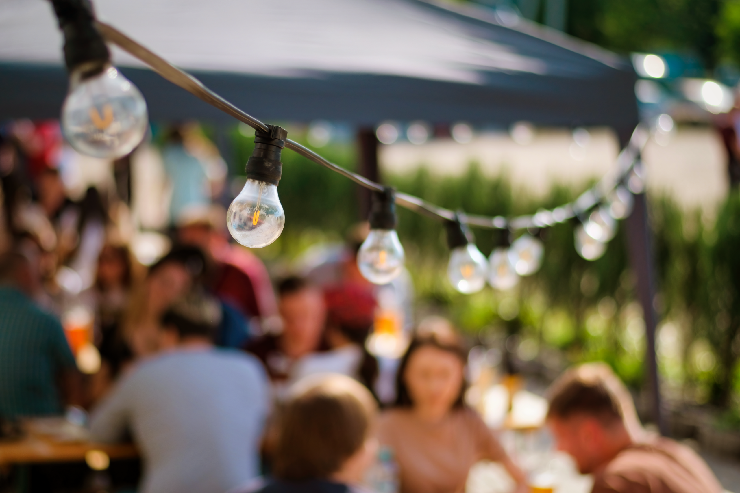 hanged-lamps-outdoor-restaurant-with-multiple-visitors-background-bbq